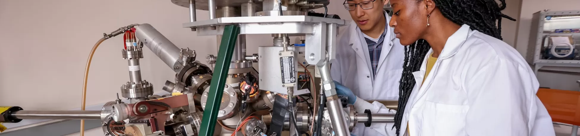2 researchers in lab coats working on a project