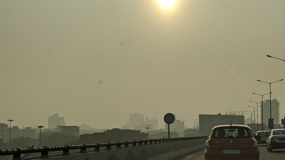  image of a smoggy sky with the back of a car driving away